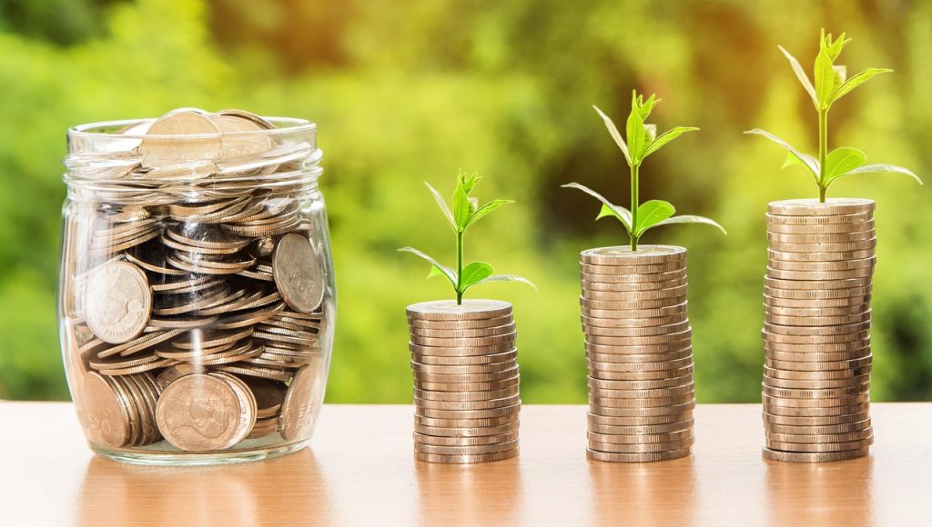 Representação conceitual de dinheiro, moedas e recursos financeiros associados a bancos, depósitos e investimentos.